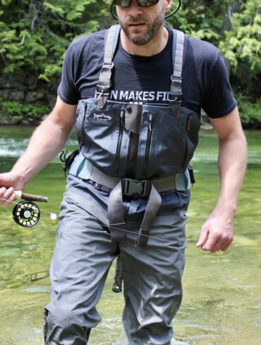 Author Chris Maxcer wearing the Patagonia Expedition Zip-Front Waders while fly fishing on a river in Idaho.
