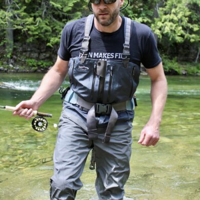 Author Chris Maxcer wearing the Patagonia Expedition Zip-Front Waders while fly fishing on a river in Idaho.