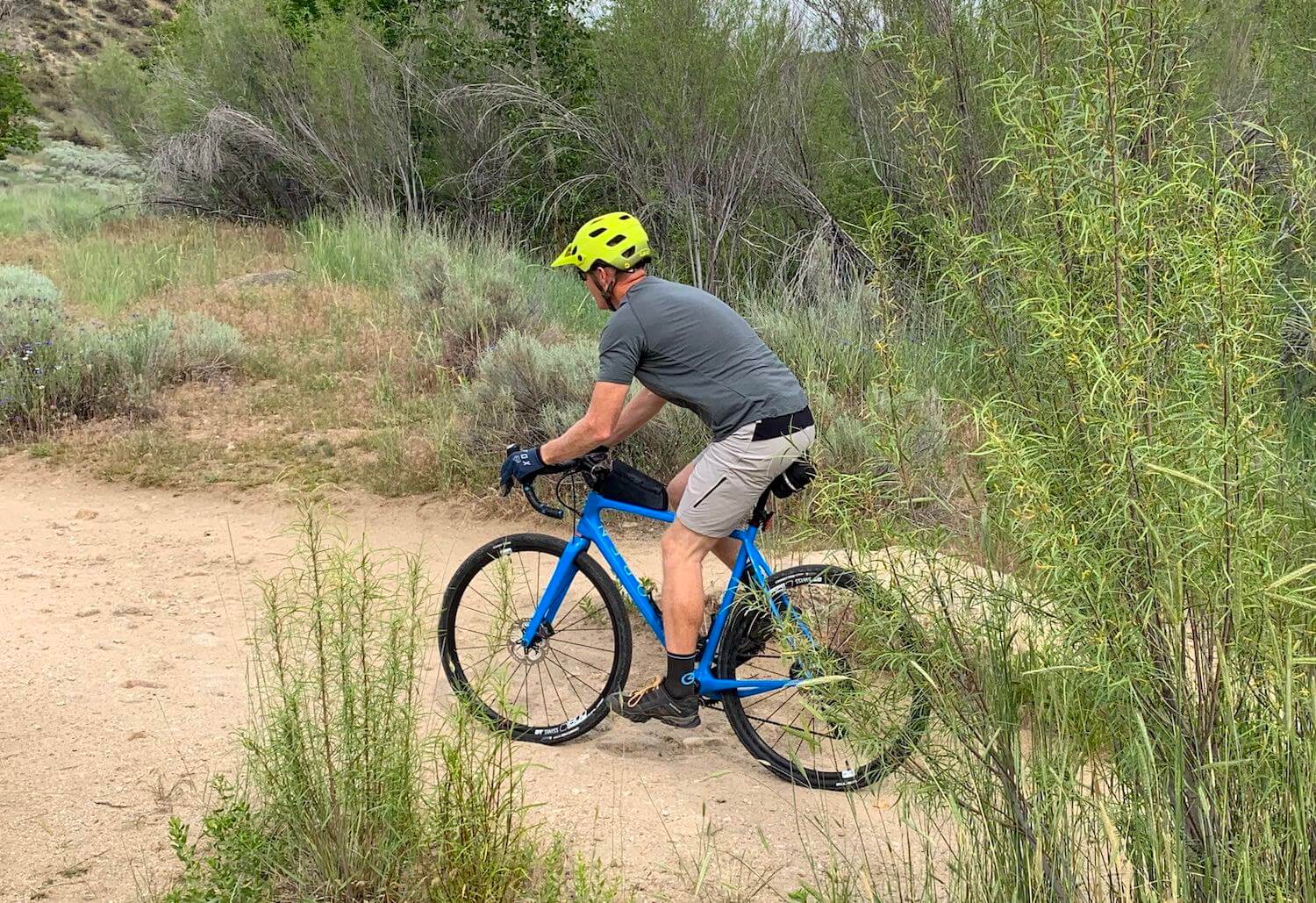 This review photo shows the author testing the Showers Pass Apex Merino Tech shirt while riding a gravel bike.