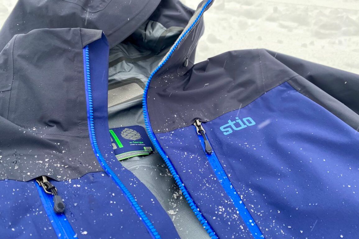 This review photo shows the Stio Objective Pro Jacket outside in a closeup with snow during the testing process.