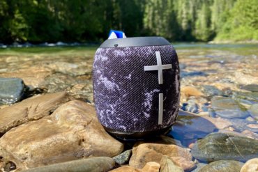 This review photo shows the Ultimate Ears Wonderboom 2 waterproof bluetooth speaker outside near a river.