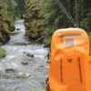 This photo shows a waterproof fishing backpack near a river and stream.