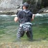 This best fly fishing hip pack photo shows the author testing a fishing hip pack in a river while fly fishing during the review process.
