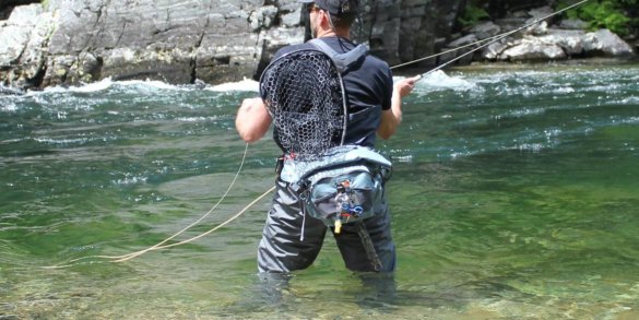 This best fly fishing hip pack photo shows the author testing a fishing hip pack in a river while fly fishing during the review process.