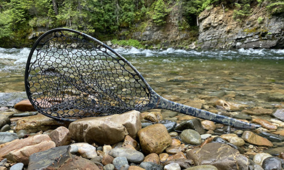 This review and testing photo shows the Fishpond Nomad Mid-Length Net near a river during the testing and review process.
