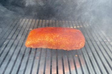 This photo shows a smoking pork loin on a Traeger Pro 575 Pellet Grill.