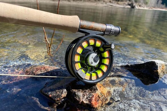 Closeup of Orvis Recon Fly Rod Outfit Hydros Reel on wet rock near river.