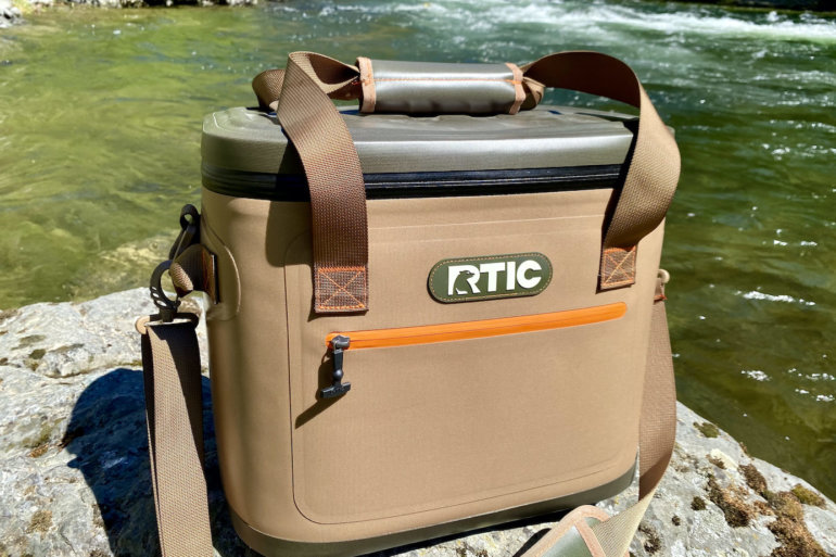 This review photo shows the RTIC Soft Pack 30 Cooler next to a river.