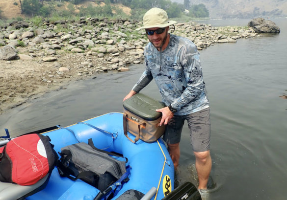 This photo shows the author testing the UA Iso-Chill Shorebreak Long Sleeve shirt during the review process while getting ready for a whitewater rafting trip.
