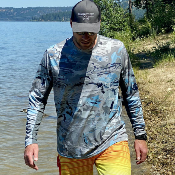 This review photo shows the author testing a Under Armour UA Iso-Chill Shorebreak Long Sleeve fishing shirt on a sunny beach.