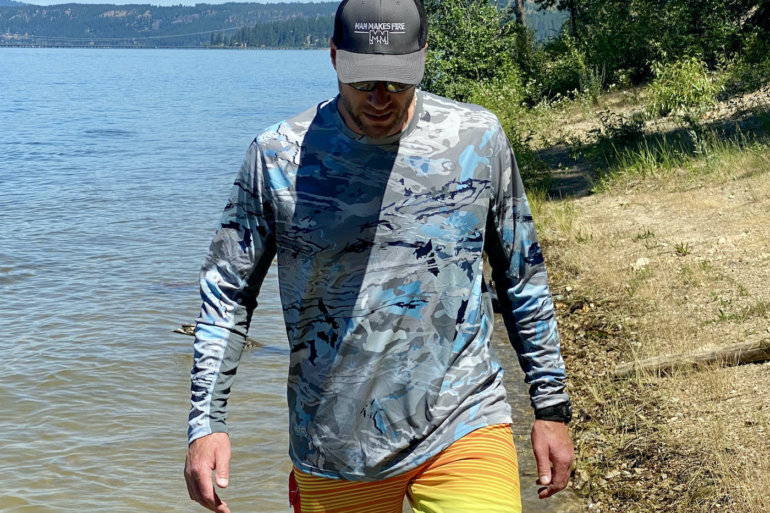 This review photo shows the author testing a Under Armour UA Iso-Chill Shorebreak Long Sleeve fishing shirt on a sunny beach.