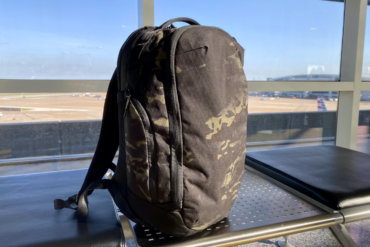 This review photo shows the Able Carry Max Backpack on a bench in an airport during the testing and review process.