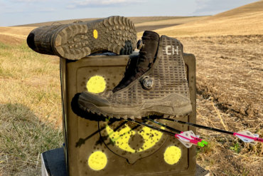 This review photo shows the Under Armour UA CH1 GORE-TEX Hunting Boots on an archery target out in a field.
