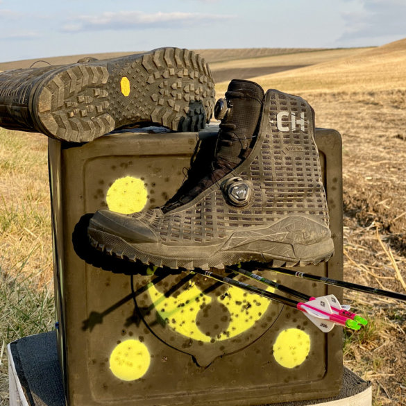 This review photo shows the Under Armour UA CH1 GORE-TEX Hunting Boots on an archery target out in a field.