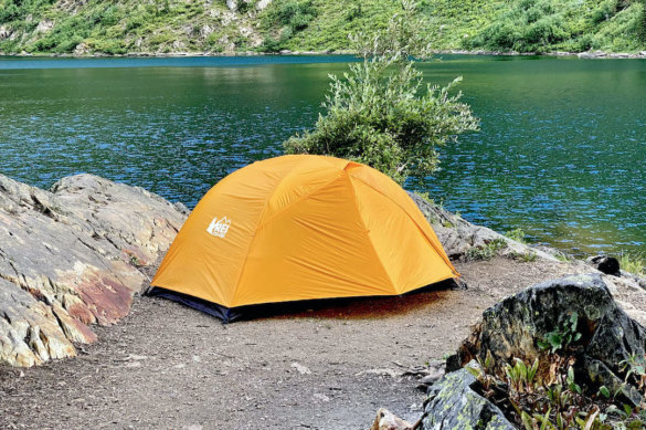 This review photo shows the REI Co-op Half Dome SL 2+ 2-person backpacking tent setup near a mountain lake.