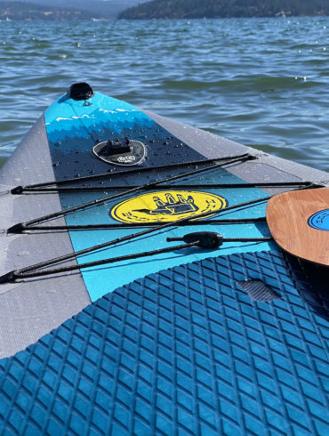 This review photo shows the Body Glove Performer 11 stand-up paddle board on a lake during the testing process.