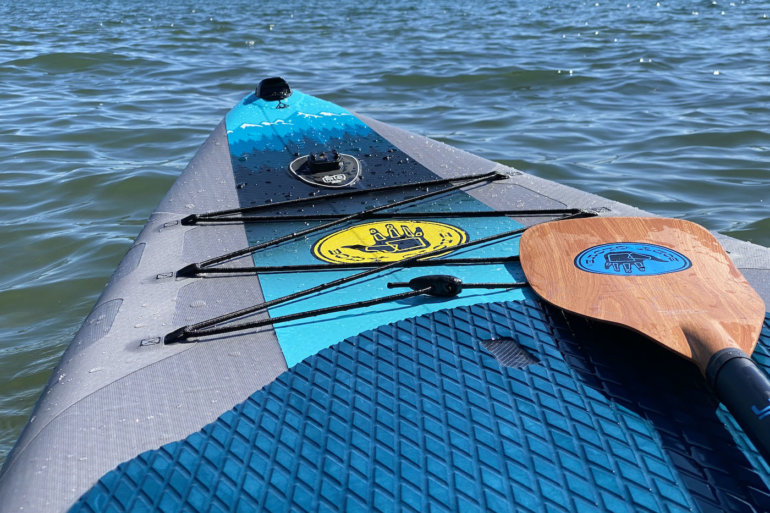 This review photo shows the Body Glove Performer 11 stand-up paddle board on a lake during the testing process.