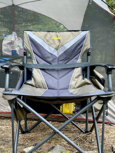 This photo shows the Cabela's Big Outdoorsman XL Fold-up Chair set up at a camping site.