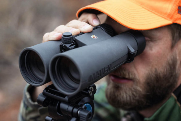 This photo shows a closeup of a hunter using the Maven C.4 15x56 binoculars on a tripod.
