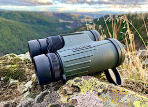 This best gifts for hunters photo shows a pair of Vortex 10x42 binoculars outside during a hunt.