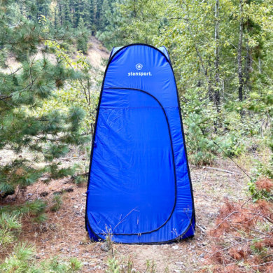 This review photo shows the Stansport Pop-Up Privacy Shelter set up at a remote campsite during the testing process.