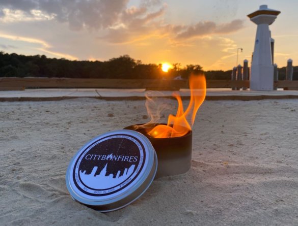 This photo shows a City Bonfire portable fire pit lit with fire on a beach.