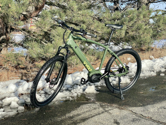 This photo shows the Vvolt Sirius ebike in the Mila green option near a biking trail.