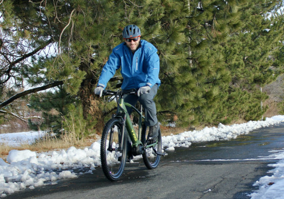 This photo shows the author riding the Vvolt Sirius ebike on a bike path in the winter.