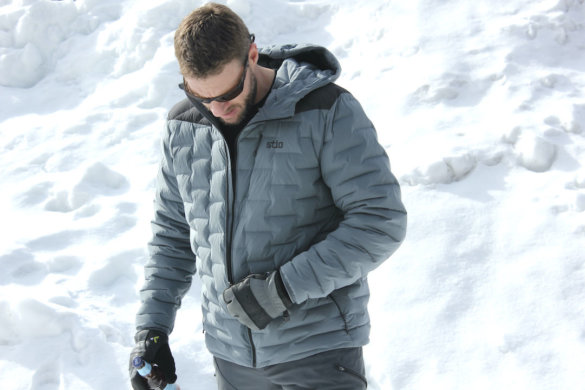 This photo shows the author unzipping the Stio Skillet Stretch Down Jacket.