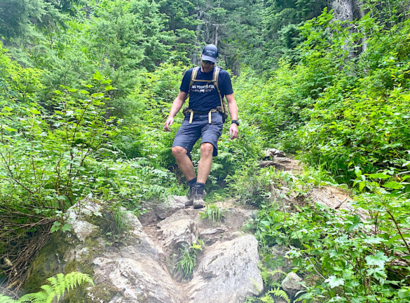 This image shows the author wearing KUHL shorts as he hikes down a steep trail while wearing a backpack.