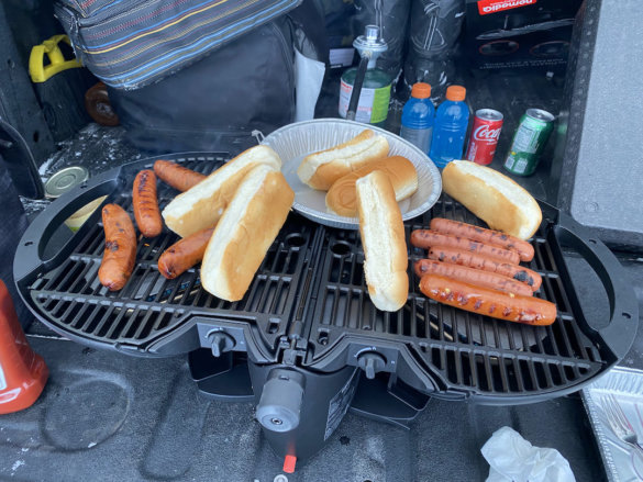 This photo shows the nomadiQ Grill with hot dogs, sausages, and buns.