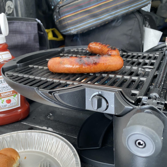 This review photo shows the nomadiQ Grill in use on the tailgate of a pickup during the testing process.