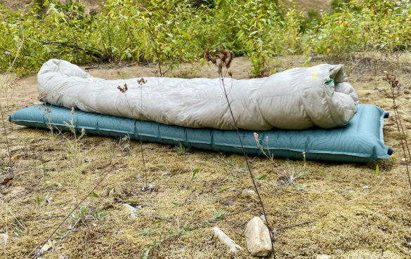 This photo shows a sleeping bag laid out on the Therm-a-Rest NeoAir Topo Luxe Sleeping Pad.