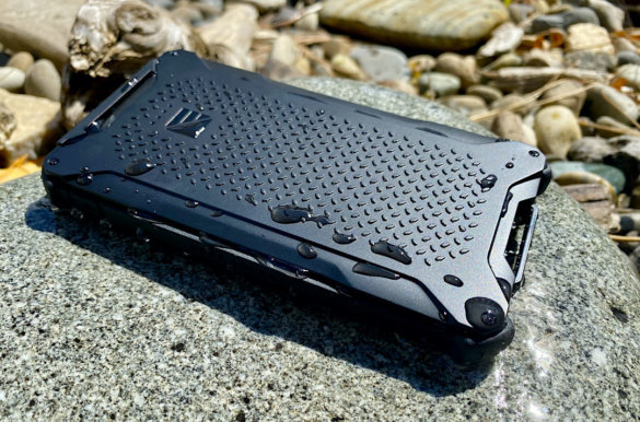 This photo shows the Dark Energy Poseidon Pro Charger outside on a rock with water droplets.