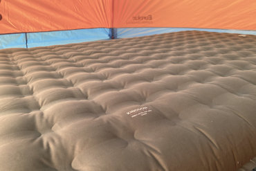 This photo shows the REI Co-op Kingdom Insulated Air Bed inflated inside of a camping tent during the testing and review process.
