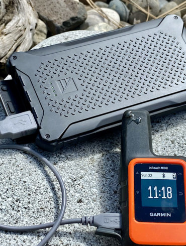 This photo shows the Dark Energy Poseidon Pro Charger charging a Garmin InReach Mini satellite messenger device.