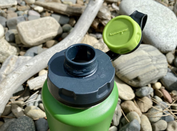 This photo shows the humangear capCAP+ open on a stainless steel water bottle.