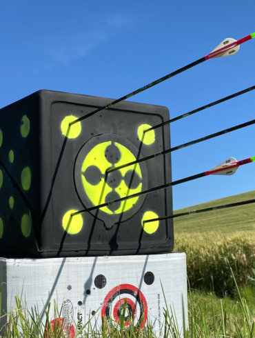 This photo shows the Rinehart RhinoBlock Archery Target in a field with arrows in it during the start of the testing review process by the author.