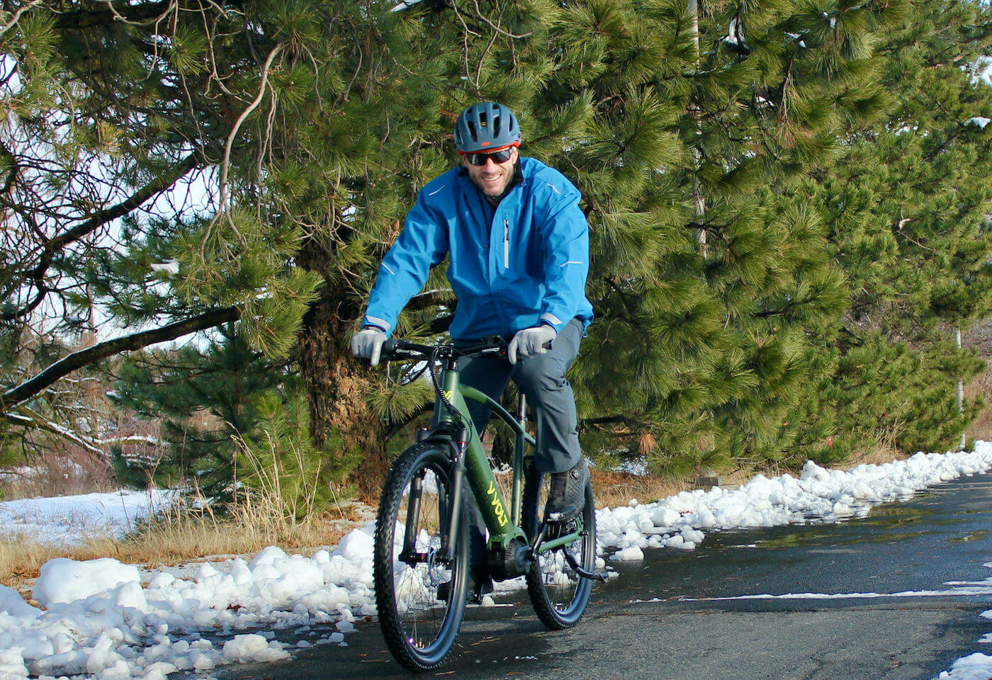 This photo shows the author riding a Vvolt Sirius ebike while wearing the Showers Pass Transit Jacket CC during the testing and review process.