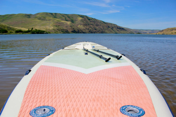 This photo shows the expansive deck on the ISLE Megalodon 2.0 15' paddle board with two paddles.