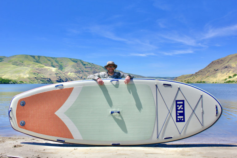 This photo shows the author standing behind the ISLE Megalodon 2.0 inflatable standup paddle board during the testing and review process.