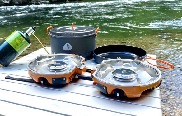 This review photo of a camp stove shows the Jetboil Genesis Basecamp Camping Stove with the included system pot and pan. 