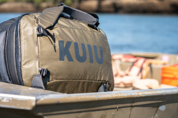 This photo shows the KUIU Waypoint 2800 Duffel travel hunting bag on a boat with water droplets.