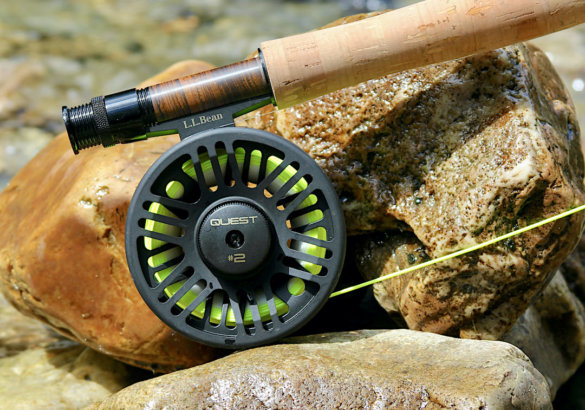 This photo shows a closeup of the L.L.Bean Quest Fly Rod Outfit reel outside on some river rock.