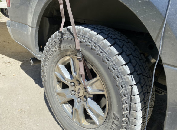 This photo shows the Roadhouse Tarp wheel straps installed on a pickup wheel.