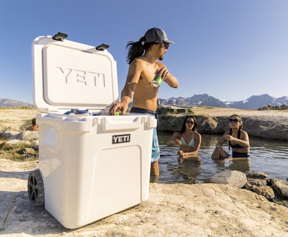 This photo shows a group of people using the YETI Roadie 48 at an outdoor hot springs.