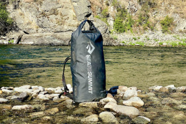 This photo shows the Sea to Summit Hydraulic Dry Pack during the testing process near a river.