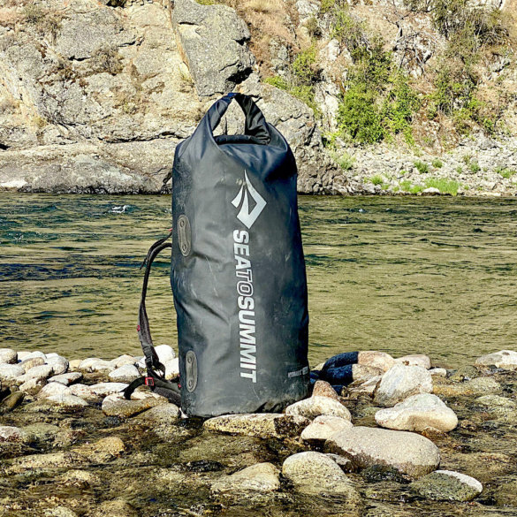 This photo shows the Sea to Summit Hydraulic Dry Pack during the testing process near a river.