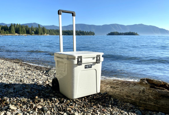 This review photo shows the YETI Roadie 48 Wheeled Cooler on a beach with its handle extended during the testing process.
