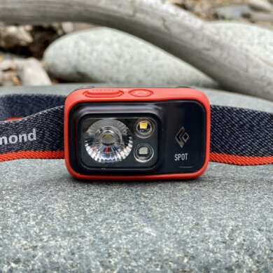 This review photo shows the Black Diamond Spot 400 Headlamp from the front view on a rock.